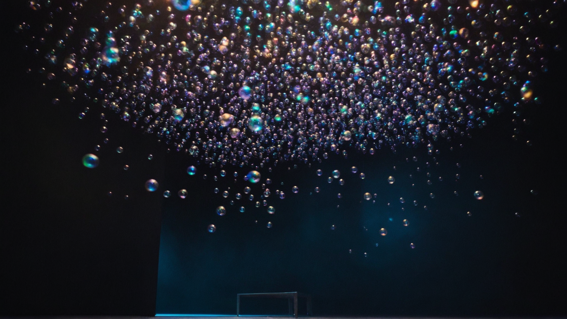 A dreamy composition of shimmering iridescent bubbles suspended in a vast dark e